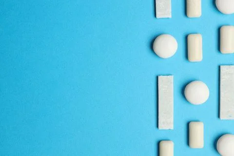 White bubble gums on blue background, flat lay. Space for text Stock Photos