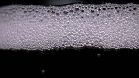 White bubbles floating on a liquid. light change Stock Footage 89307307