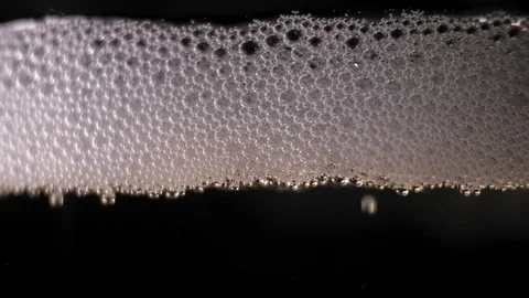 White bubbles floating on a liquid. slow motion Video stock 89306312