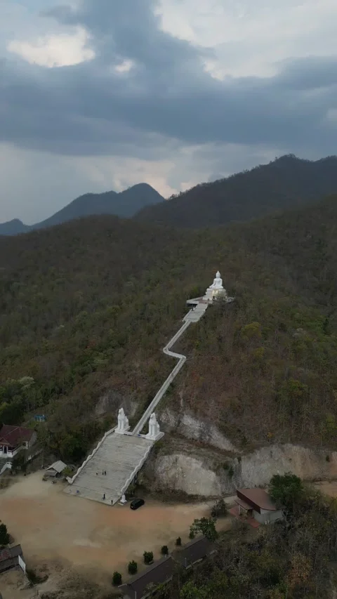 White Buddha Statue Sitting Atop a Verdant Mountain in Pai, Mae Hong Son, Stock Footage 335600768