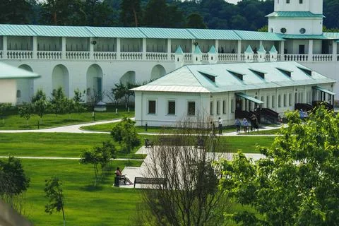 White building complex with green roofs and landscaped garden in the monaster Stock Photos