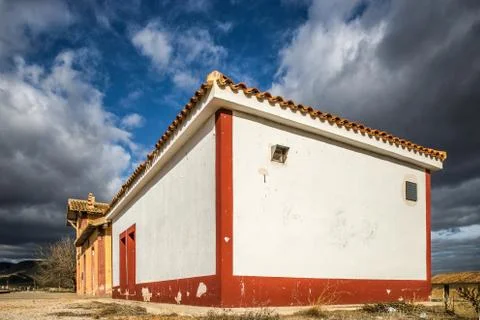 White building with red frames on its corners under a sky full of clouds Stock Photos