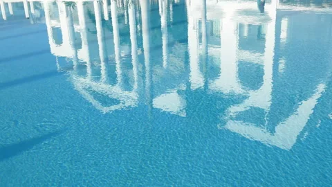 The white building is reflected in the blue water of the swimming pool, the p Stock Footage 129733165