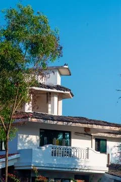 White building with second and third floors and tiled roof Stock Photos
