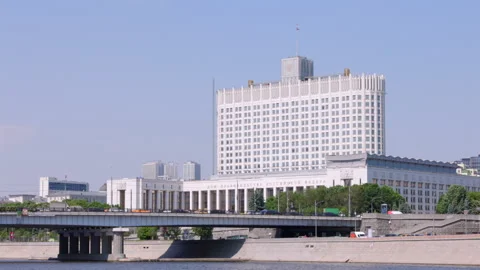 White building towers over river, bridge spans below Stock-Footage 336015111