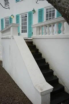 White Building, Turquoise Shutters, Glowing Lantern, And Steps In Portmeirion. Stock Photos