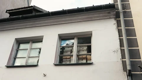 White building with two windows and a gutter on the side Vidéo 275115243