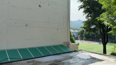 White Building Wall Texture with Distant Football Field Stock Footage 339272064