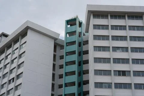 White buildings flank a turquoise elevator shaft Stock Photos