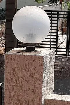 White Bulb of Lamp on Gate Post Stock Photos