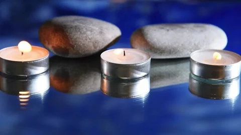 White burning candles in water, reflection of waves Stock Footage 167654646
