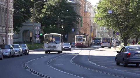 White bus and red-and-creamy tram pass a curve at Komsomola Street Stock Footage 67468133