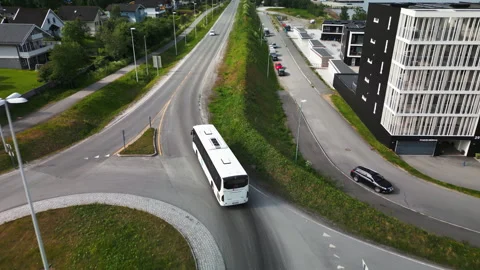 White bus drive through roundabout in Tromso neigborhood, aerial tracking Stockbeeldmateriaal 249650719