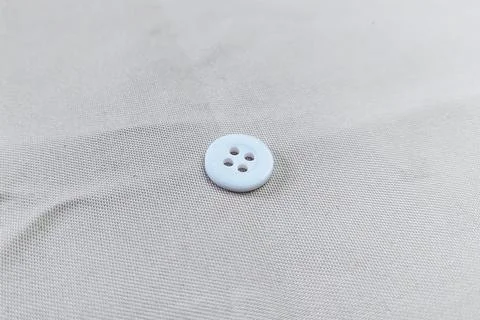 A White Button on a fabric texture Stock Photos