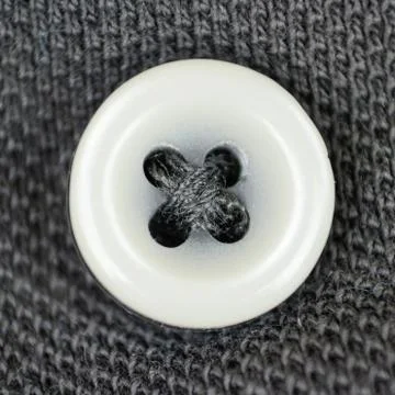 White button on a grey fabric in macro shot 库存照片