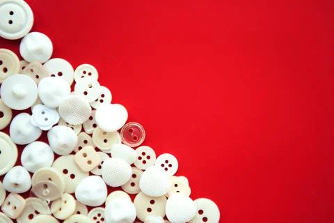 White buttons on red background, in corner with copy space, flat lay Stock Photos