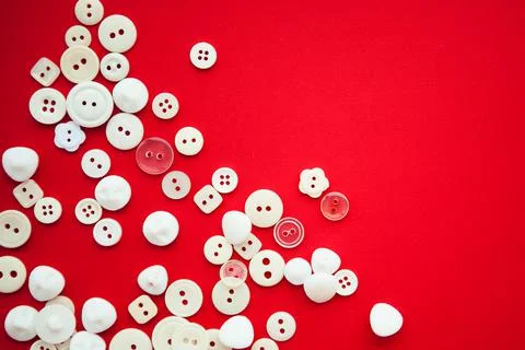 White buttons on red background, in corner with copy space, flat lay Stock Photos