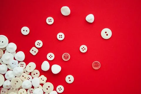 White buttons on red background, in corner with copy space, flat lay Stock Photos
