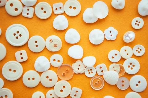 White buttons on yellow background, flat lay Stock Photos