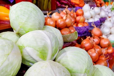 White cabbage close-up against a background of golden and white onions in blu 스톡 사진