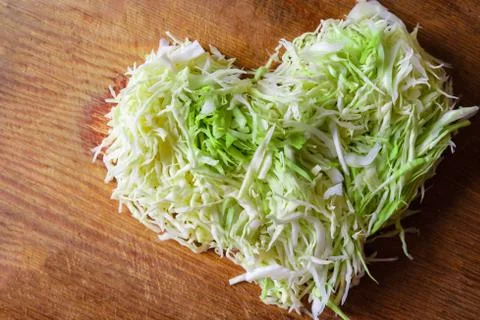 White cabbage finely chopped in the shape of a heart. Stock Photos