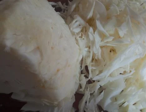 White cabbage sliced ​​thinly in the kitchen Stock Photos