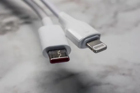White cables for charging and synchronization with Type - C and Lightning c.. Stock Photos
