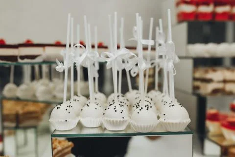 White cake pops adorned with black sprinkles Foto stock
