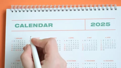 White calendar 2025 on orange background close-up, planning concept. Stock Footage 284731073