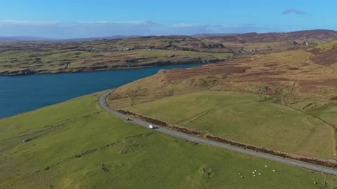 White camper van driving along scottish coastal road in isle of skye 库存影片 334059014