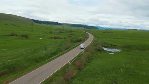 White camper van driving through green countryside landscape Stock Footage 344647968