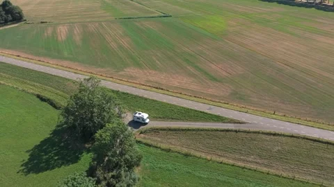White camper van exiting a driveway onto a rural country road Stock Footage 341875277