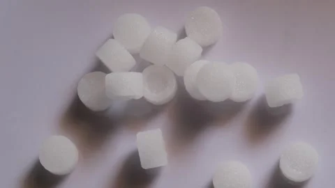 White camphor tablets scattered on a plain surface Видео 330657895