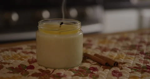 White candle blown out in kitchen with cinnamon sticks dim closeup Stock Footage 249288063