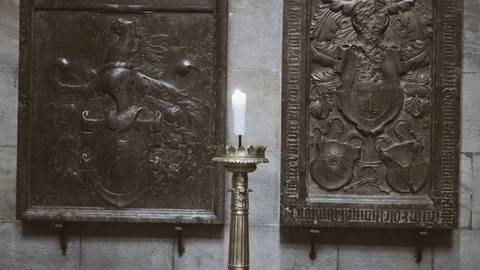 White Candle Burning Inside St Vitus Cathedral With Religious Basreliefs in the  Stock Footage 72098554