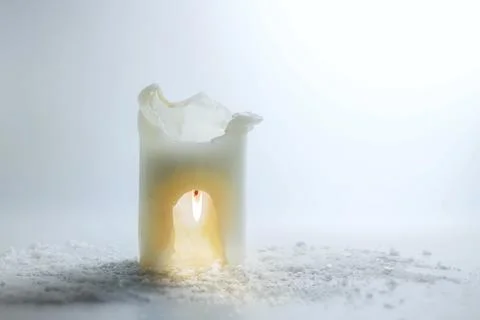White candle is burning upside down in a carve, saving heat and energy concept, Stock Photos