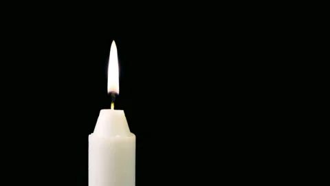 A white candle burns on a black background. Copy space Stock Footage 122063979