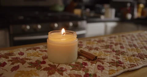 White candle lit in kitchen with cinnamon sticks dim wide Stock Footage 249288205