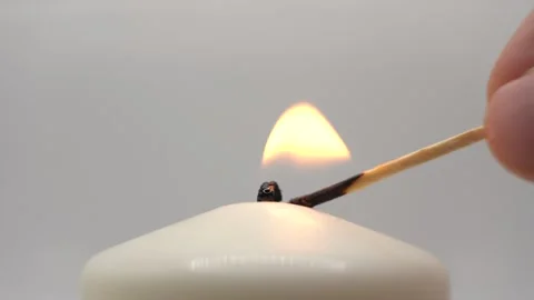 A white candle is lit with a match 库存影片 293062650