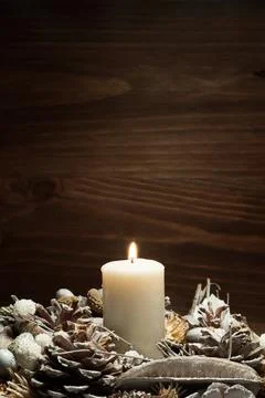 White candle lit with pine cone ornaments. High quality and resolution beautiful Stock Photos