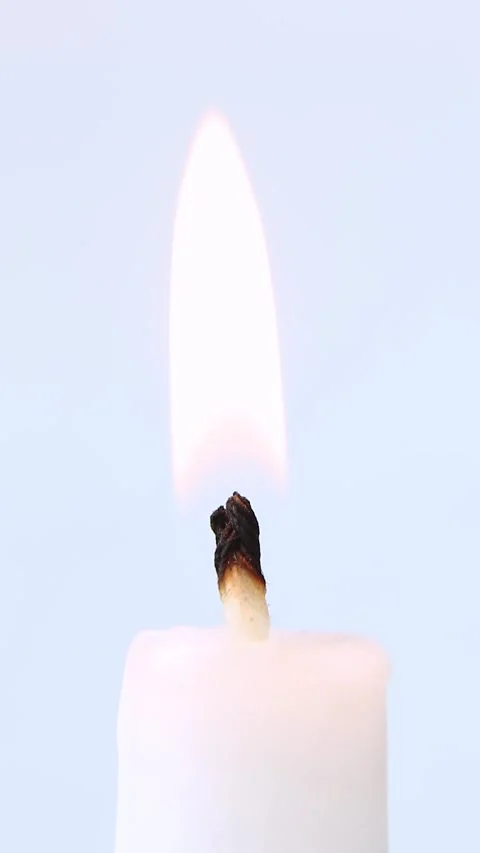 A white candle on a white background burns with a flame. Lighting a candle. Stock Footage 237202021