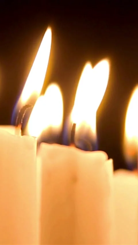 White candles burning with bright flames in darkness Stock Footage 334168485