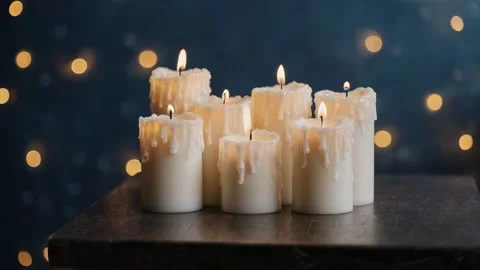 White candles burning on the table, blue bokeh in the background Stock Footage 317376912