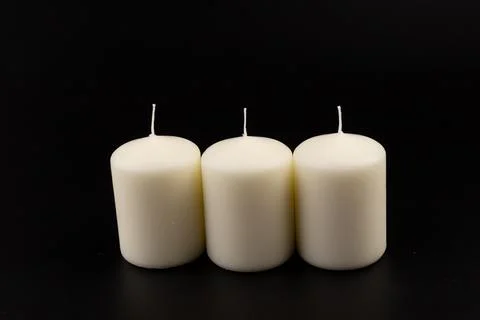 White candles on dark background. Close-up, copy space. Stock Photos