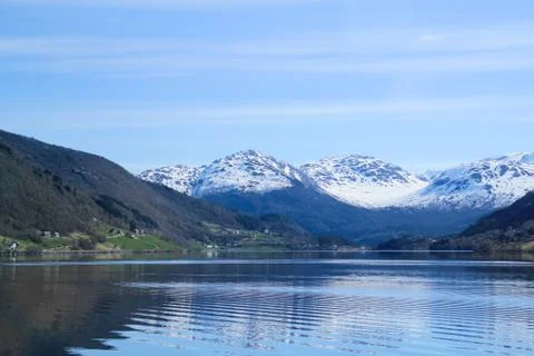 White capped mountain reflected in crystal clear lake. Stock Photos