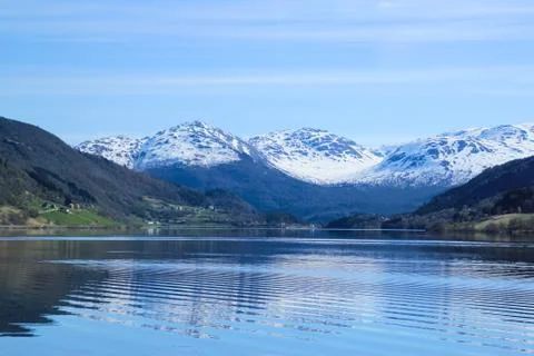 White capped mountain reflected in crystal clear lake. Stock Photos