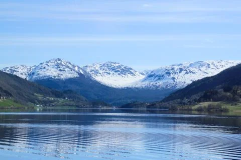 White capped mountain reflected in crystal clear lake. Stock Photos