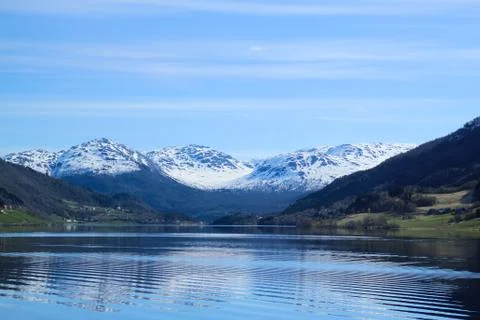 White capped mountain reflected in crystal clear lake. Stock Photos