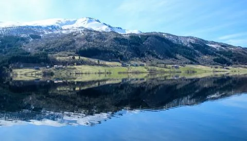 White capped mountain reflected in crystal clear lake. Stock Photos