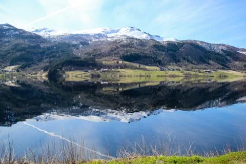 White capped mountain reflected in crystal clear lake. Stock Photos